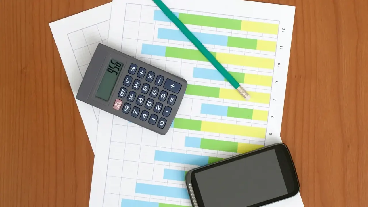 Calculando as contas pessoais com uma calculadora e um telefone celular em cima