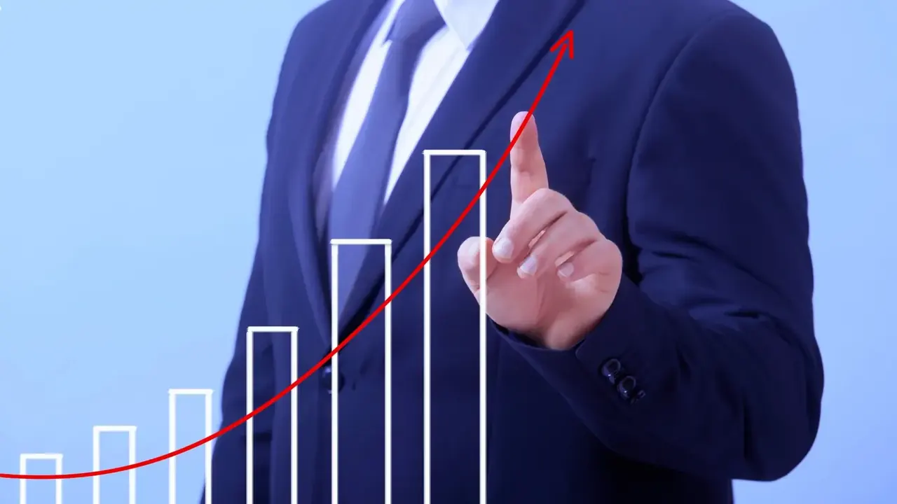 Um homem de terno e gravata apontando o aumento da inflação em um gráfico.