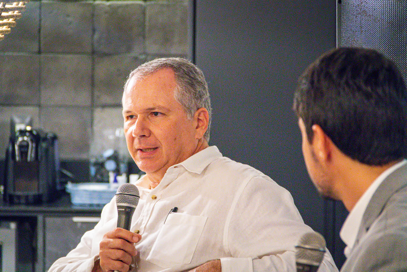 Diálogo ao microfone entre convidados no encontro do Club